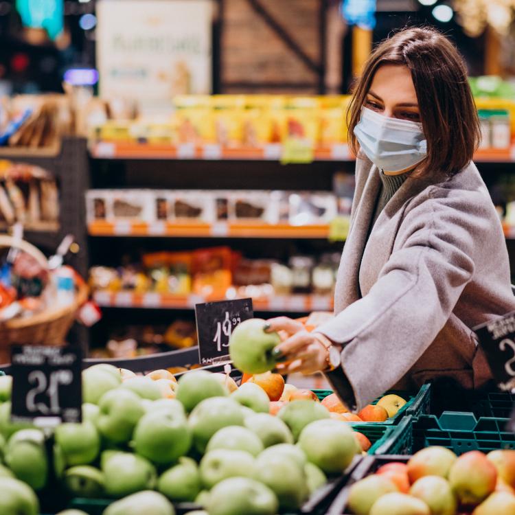 Mujer comprando frutas y verduras.