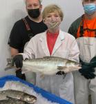 Mujer y dos hombres mostrando un Salmon