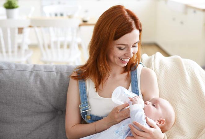 Mamá alimentando al bebé con leche de fórmula